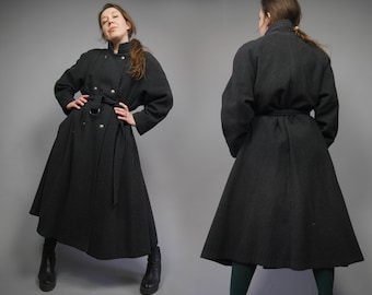 May include: A long black wool coat with a double breasted closure, a belt, and a flared skirt.
