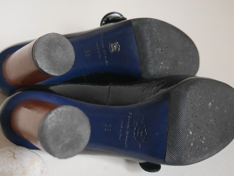 Pode incluir: Sapatos de salto alto de verniz preto com acabamento azul e saltos de madeira. Os sapatos t&ecirc;m uma sola texturizada e o nome da marca "Sonia Rykiel" est&aacute; impresso na sola.