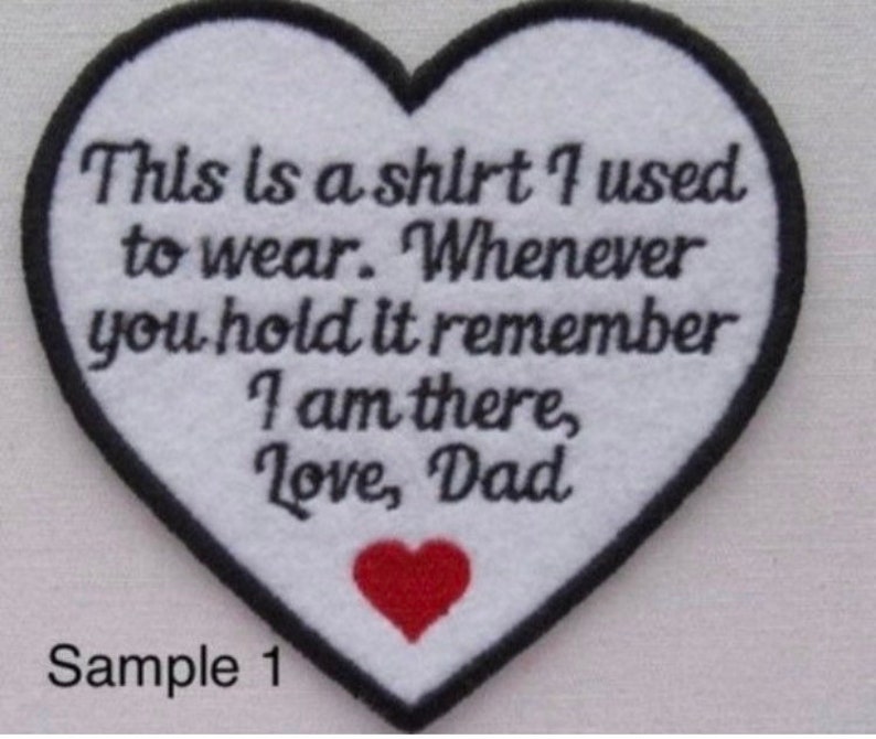 May include: A heart-shaped patch with a black border and white center. The patch features the text "This is a shirt I used to wear. Whenever you hold it remember I am there, Love, Dad" and a red heart.
