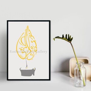 Könnte beinhalten: Ein gerahmter Druck mit einem gelben arabischen Kalligraphie-Design in Form eines Tränen tropfens. Die Kalligraphie ist auf weißem Hintergrund und der Rahmen ist schwarz. Der Text am unteren Rand des Drucks lautet "Rashad Sultan Gallery".