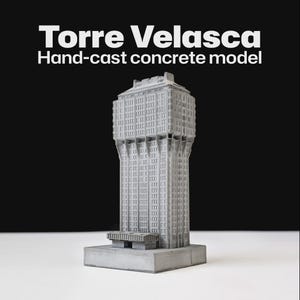 Może przedstawiać: Ręcznie odlewany model betonowy budynku Torre Velasca. Model jest w kolorze jasnoszarym i posiada szczegółowe elementy architektoniczne, w tym okna i podpory konstrukcyjne. Tekst "Torre Velasca Hand-cast concrete model" jest wyświetlany u góry.