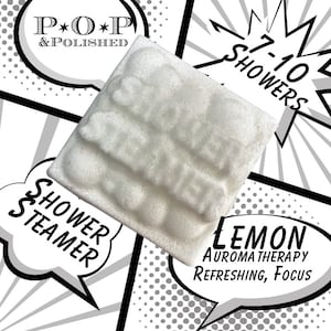 May include: A white shower steamer with a textured surface, featuring the text "Shower Steamer" and "Lemon Aroma Therapy Refreshing, Focus". The packaging indicates the product is for 7-10 showers.