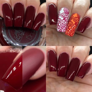 Puede incluir: Primer plano de u&ntilde;as manicuradas en un tono burdeos intenso. Algunas u&ntilde;as presentan intrincados dise&ntilde;os en blanco y naranja. Una u&ntilde;a tiene un acabado mate, mientras que otras son brillantes. Se muestran diferentes t&eacute;cnicas de nail art.