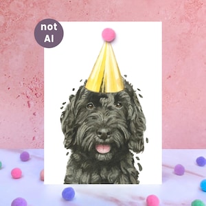 May include: A watercolor illustration of a black dog with shaggy fur wearing a shiny gold party hat with a pink pom-pom on top. The dog has brown eyes and an open mouth showing its tongue. A circular purple badge with the text not AI is visible.