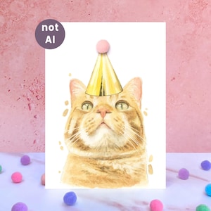 May include: A watercolor illustration of an orange tabby cat wearing a gold party hat with a pink pom-pom on top. The cat has green eyes and is looking upward. A circular purple badge in the upper left corner contains the white text not AI.