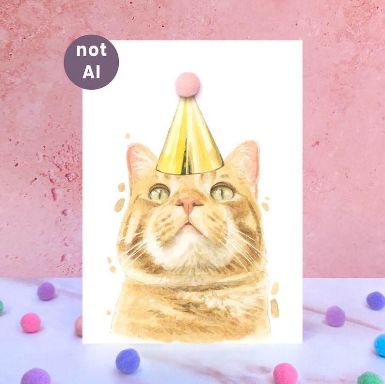 May include: A watercolor illustration of an orange tabby cat wearing a gold party hat with a pink pom-pom on top. The cat has green eyes and is looking upward. A circular purple badge in the upper left corner contains the white text not AI.
