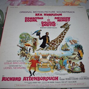 May include: A vintage vinyl record album cover for the movie Doctor Dolittle. The cover features Rex Harrison, Samantha Eggar, and Anthony Newley. The album includes a full-color story and picture booklet.