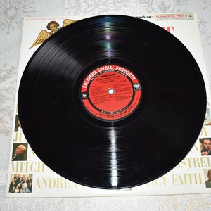 May include: A black vinyl record with a red and white label. The label says "Columbia Special Products" and "The Great Songs of Columbia Records".