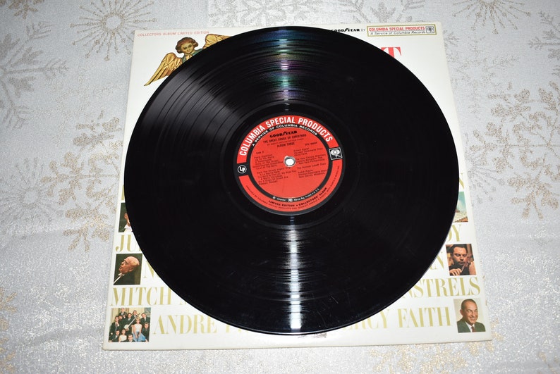 May include: A black vinyl record with a red and white label. The label says "Columbia Special Products" and "The Great Songs of Columbia Records".