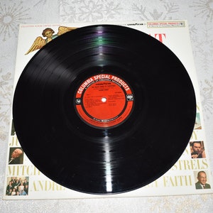 May include: A black vinyl record with a red label that says "Columbia Special Products" and "The Sound of Christmas" with a picture of a Christmas angel on the cover.