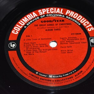 May include: A red vinyl record with a black label. The label features the text "Columbia Special Products", "A Service of Columbia Records", "Good Year", "The Great Songs of Christmas", "By Great Artists of Our Times", "Album Three", "XTV 88656", "Side 1", "O Little Town of Bethlehem", "Silent Night", "O Come All Ye Faithful", "I Saw 3 Ships, Here We", "Go A-Caroling", "It Came Upon The Midnight Clear", "Away In The Manger", "Ave Maria", "Eugene Ormandy, The Philadelphia Orch", "Julie Andrews", "Mormon Tabernacle Choir", "Percy Faith", "Mitch Miller", "Isaac Stern", "Limited Edition Collectors' Album", "Columbia", "Marcas Reg. Printed in U.S.A.", and "Produced by Columbia Special Products and Stanley Arnold & Assoc. with Norfolk Music, Inc.".