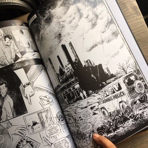 May include: A black and white comic book spread with detailed illustrations. One panel shows a cityscape with smokestacks and a vehicle labelled "MUMBAI POLICE." Text bubbles include phrases like "I think this is it, the Black Castle." The artwork is in a graphic novel style.