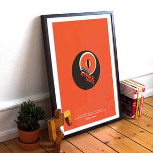 May include: A framed poster with a minimalist design featuring a black circle with a red eye and the text "2001 A SPACE ODYSSEY". The poster has an orange background and a quote by Arthur C. Clarke at the bottom.