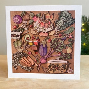 May include: A watercolor illustration of a variety of fresh produce, including vegetables, fruits, and herbs, arranged around a vintage-style pot with a lid. The illustration is set against a brown background.