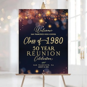 May include: A navy blue sign on a wooden easel, with gold text that reads "Welcome, Class of 1980, 50 Year Reunion Celebration." The sign includes the school name and date. The top of the sign has a string of lights.