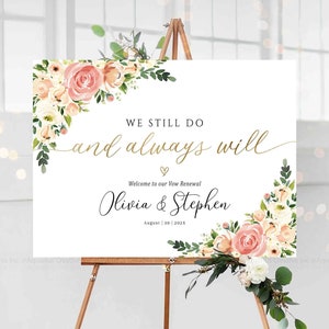 Pode incluir: Uma placa branca em um cavalete de madeira com detalhes florais, anunciando uma renovação de votos. A placa diz "WE STILL DO and always will" em letras douradas, com os nomes "Olivia & Stephen" e a data de 30 de agosto de 2023.