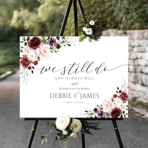 Puede incluir: Un cartel blanco con un diseño floral en tonos rosa, rojo y morado. El cartel dice "we still do and always will" y "Welcome to our Vow Renewal Debbie & James August 30 2023".