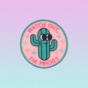 Peut inclure: Un patch brodé rose et vert avec un cactus et le texte "Watch Out, I'm Prickly".