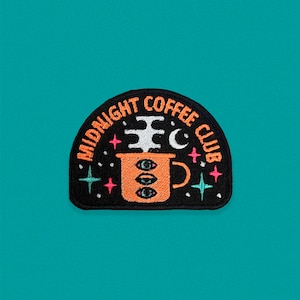 May include: Black and white embroidered patch with the text "Midnight Coffee Club" in a circle around a stylised orange coffee cup with a crescent moon and stars.