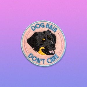 May include: A pink and blue embroidered patch with a black and tan dog's head and the text "Dog Hair Don't Care".