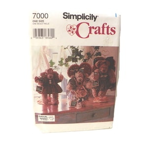 May include: Simplicity Crafts sewing pattern for teddy bears. The pattern includes instructions for creating multiple teddy bear designs. The package has a barcode and the text "7000 ONE SIZE UNE SEULE TAILLE". The Dream Babies logo is visible.