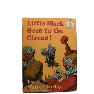 May include: A vintage children's book cover titled "Little Black Goes to the Circus!" with illustrations of a clown, a boy on a horse, and other circus performers. The cover is predominantly orange and red.
