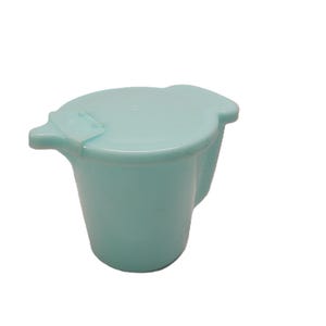 May include: A pale blue plastic jug with a matching lid. The jug features a spout and a rounded body. The lid has a small tab for easy opening. The jug is made of a smooth, solid material.