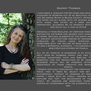 K&ouml;nnte beinhalten: Eine Frau mit langen grauen Haaren, die ein schwarzes Oberteil und Schmuck tr&auml;gt, lehnt an einem Baum. Der Text rechts beschreibt sie als Juwelierin seit 29 Jahren, inspiriert von Natur und antiker Architektur.