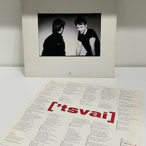 May include: A vinyl record album by Purple Schulz, titled "['tsvai]", with a black and white photo of two men. The album cover is white with red text. The lyrics sheet is also visible.