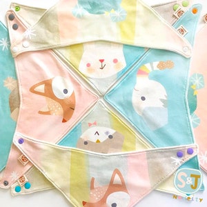 May include: Set of six colorful baby bibs with different animal designs. Each bib features a different animal, including a fox, a bunny, an owl, and a whale. The bibs are made of soft, absorbent fabric and have a snap closure.