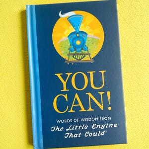 May include: A navy blue book with the words "YOU CAN!" in yellow. The cover features a blue train illustration inside a yellow circle, with the text "WORDS OF WISDOM FROM The Little Engine That Could".