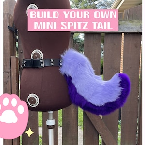 Puede incluir: Una mini cola Spitz de piel sintética morada y lila claro, sujeta a un cinturón negro. El cinturón está abrochado alrededor de un maniquí. El texto de la imagen dice "BUILD YOUR OWN MINI SPITZ TAIL".