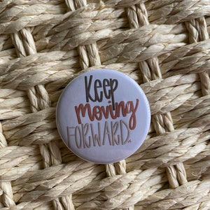 May include: White button with the text "Keep moving forward" in brown and orange lettering.