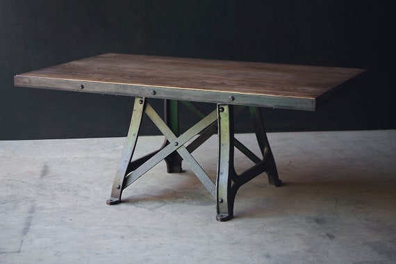 An industrial dining table with original cast iron, "4445" base.