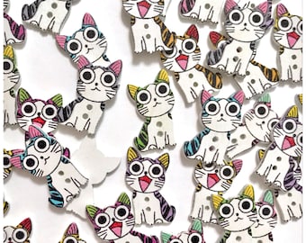 May include: A collection of small, flat, wooden buttons shaped like cartoon cats. Each button features a white cat with large eyes, a pink open mouth, and colorful striped patterns on the ears and tail in shades of purple, blue, green, and orange.