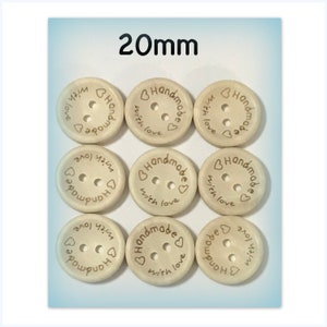 May include: Nine beige wooden buttons, each 20mm in diameter, arranged in a grid. Each button has two holes and is inscribed with "Handmade with love" in a brown script, accompanied by a heart symbol.