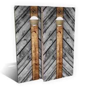May include: A pair of wooden cornhole boards with a chevron pattern in gray and brown. The boards have a circular hole in the center and a logo with the text "COUNTRY CRAFT" in a circle.