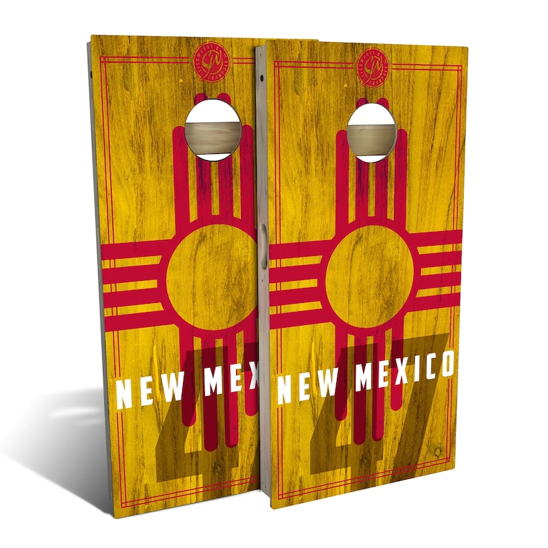May include: Two wooden cornhole boards with a distressed yellow wood grain background. The boards feature the New Mexico state flag with a red Zia symbol and the words "New Mexico" in white text.