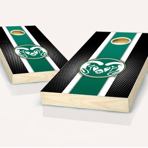 May include: Two wooden cornhole boards with a black and white striped background and a green stripe down the center. The boards feature a green and gold logo of a ram's head.