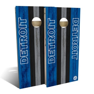 May include: A pair of blue and gray wooden cornhole boards with the word "DETROIT" printed in white on each board.