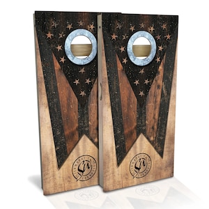 May include: Two wooden cornhole boards with a distressed American flag design. The boards feature a dark brown and black pattern with star accents and metal ringed holes. The Slick Woody's Cornhole logo is printed on the bottom.