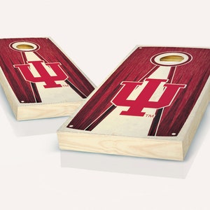 May include: Two wooden cornhole boards with a red and cream design. Each board features the Indiana University logo and a circular hole. The boards have a natural wood frame and are angled with wooden legs.