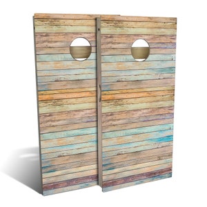 May include: Two wooden cornhole boards with a distressed, weathered, and multi-colored wood grain pattern. Each board has a circular hole cut out in the center.