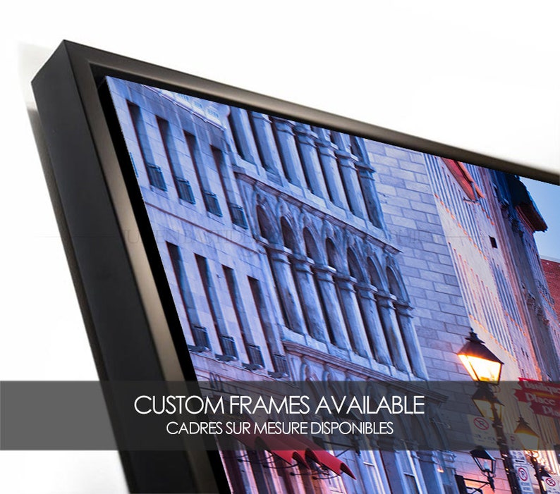 Puede incluir: Una fotograf&iacute;a enmarcada de una escena de calle de la ciudad con edificios, una farola y un toldo rojo. El texto "CUSTOM FRAMES AVAILABLE" y "CADRES SUR MESURE DISPONIBLES" es visible en la parte inferior de la imagen.
