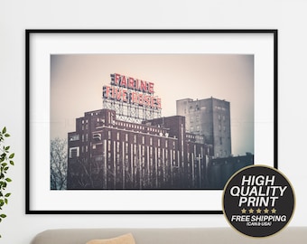 Puede incluir: Una fotografía en blanco y negro de un edificio con un letrero de neón rojo que dice "Farine Five Roses".
