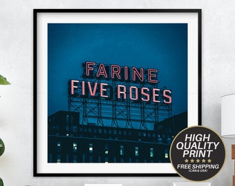 Puede incluir: Un letrero de neón vintage con el texto "Farine Five Roses" en letras de neón rosa sobre un cielo azul oscuro. El letrero está montado en un edificio con ventanas.