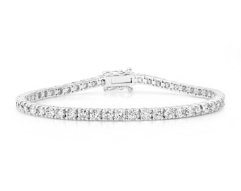 Puede incluir: Un brazalete de tenis de plata con una fila de piedras redondas y transparentes.