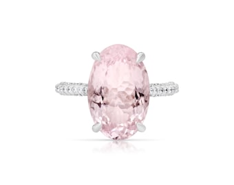 Op de afbeelding: Een delicate ring met een grote ovale roze edelsteen, omringd door een band van kleinere diamanten.