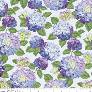May include: A fabric pattern featuring a repeating floral design of hydrangeas in shades of blue, purple, and yellow. The flowers are set against a light blue background with a subtle, textured pattern, and green leaves.