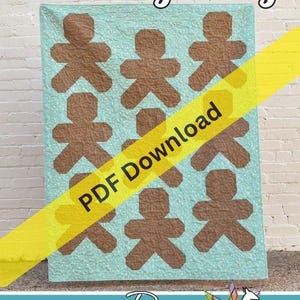 Può includere: Una trapunta con un motivo ripetuto di omini di pan di zenzero marroni su sfondo azzurro a pois bianchi. Il testo Baking Day è in alto e una fascia diagonale gialla riporta PDF Download. In basso è presente Running Doe Quilts.